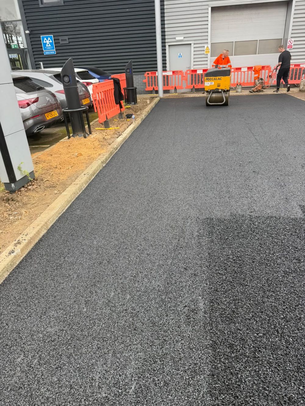 Tarmac surfacing to a commercial car park with a roller