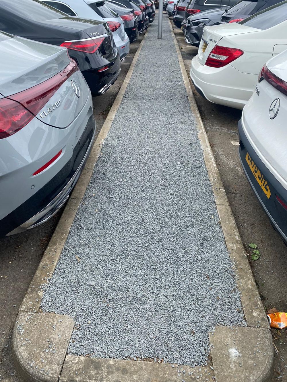 Gravel path and block edging along a car park